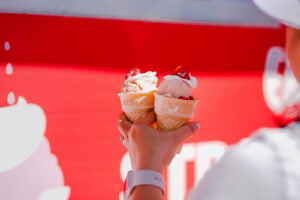 Person holding two Strawberry Sundaes at Ekka 2023