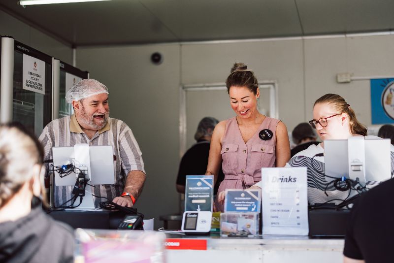 Volunteers working at The Common Good's Ekka Strawberry Sundae stalls serving customers ice cream