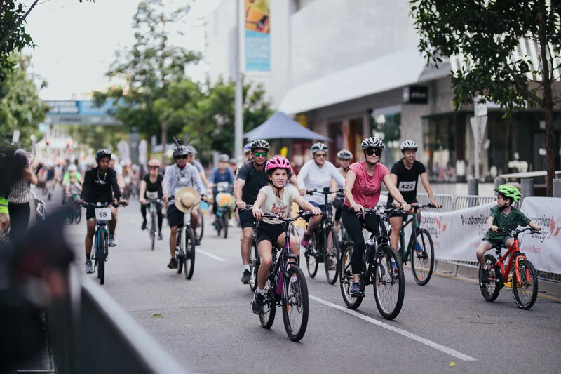 Families riding bikes through Brisbane to fundraise for The Common Good in the Tour de Brisbane